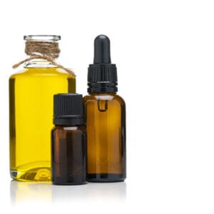 Three amber glass bottles with yellow liquid, including a dropper bottle.