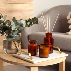 Cozy wooden table with amber glass bottles and eucalyptus arrangement.